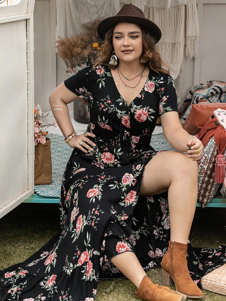 Woman in a black floral maxi dress sitting on a bench in a casual setting