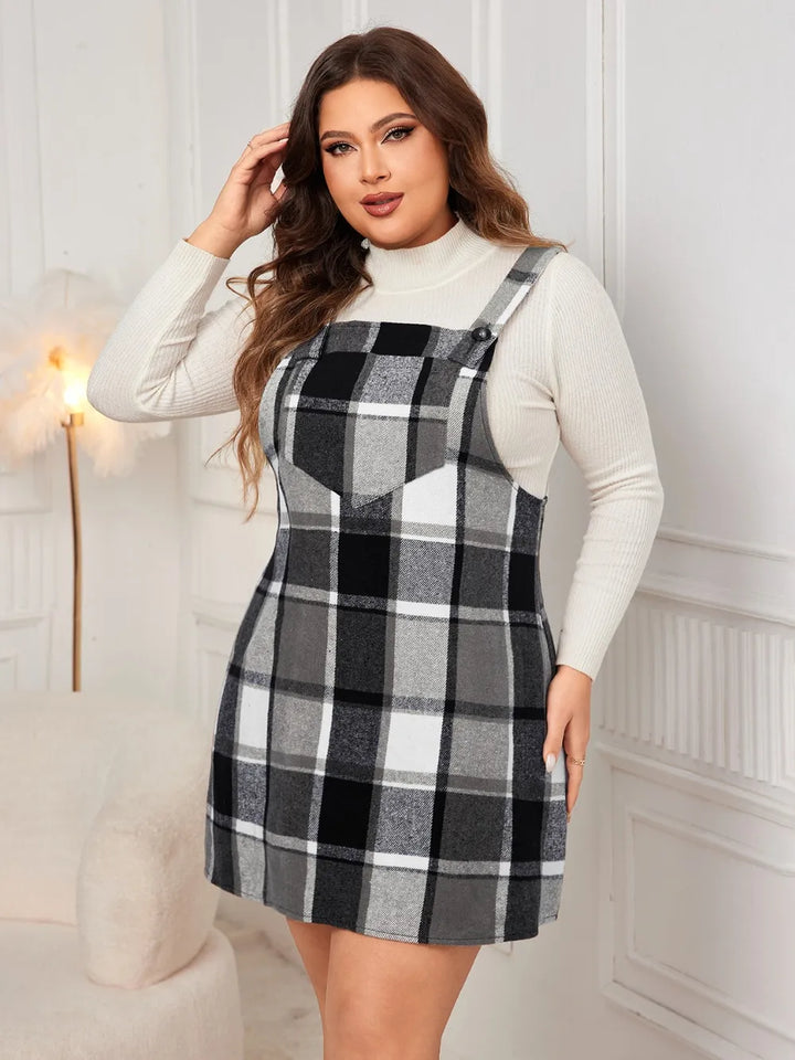 Woman wearing a black and white checkered dress over a white long-sleeve shirt in a room with decorative elements.