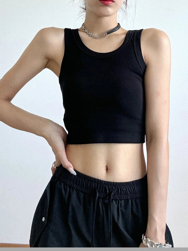 Person wearing a black tank top and black pants against a white background