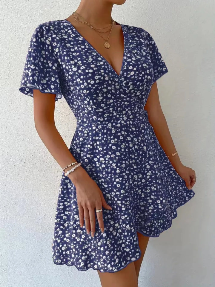 Woman wearing a blue floral dress against a white background