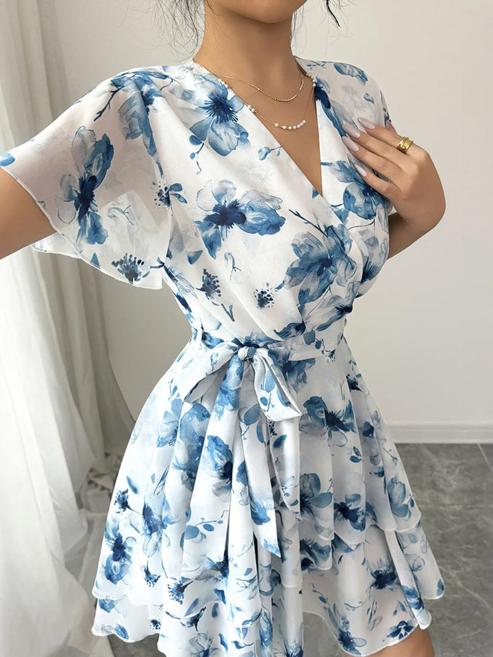 White Mini  Wrap dress with blue floral pattern worn by a person indoors.