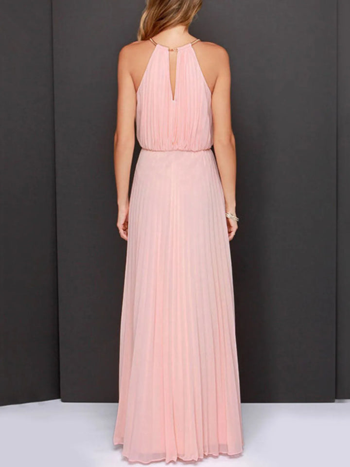 Woman wearing a long pink dress against a dark background