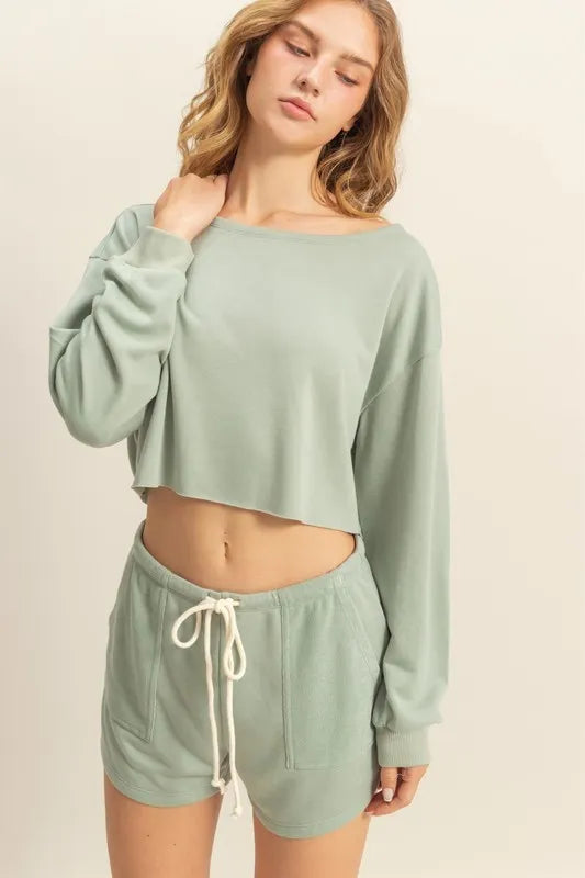 Woman wearing a light green lounge set on a beige background