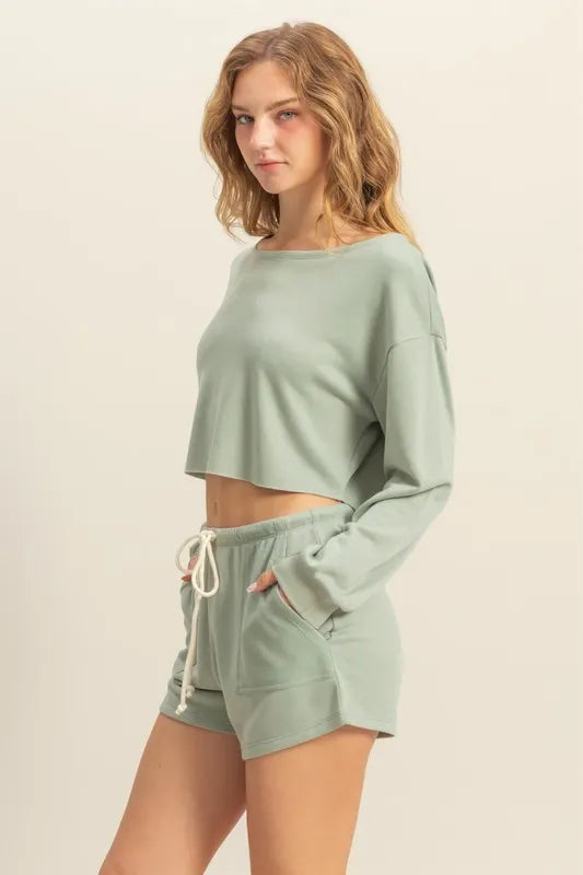 Woman wearing a light green lounge set on a beige background