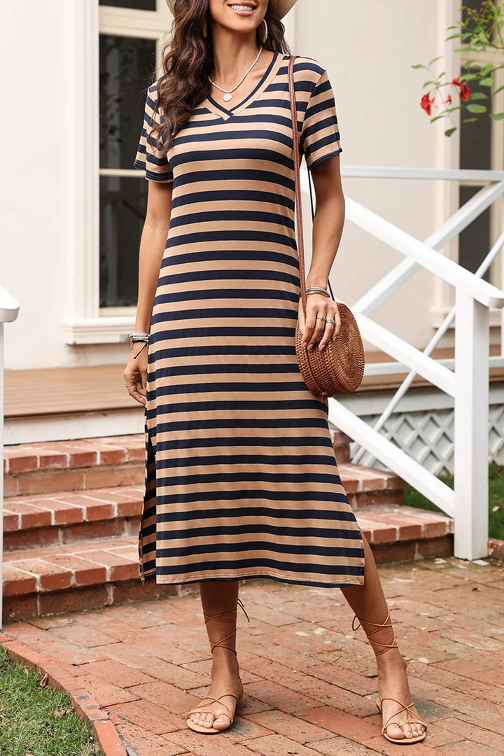 Woman wearing a brown casual striped dress standing on a brick path.