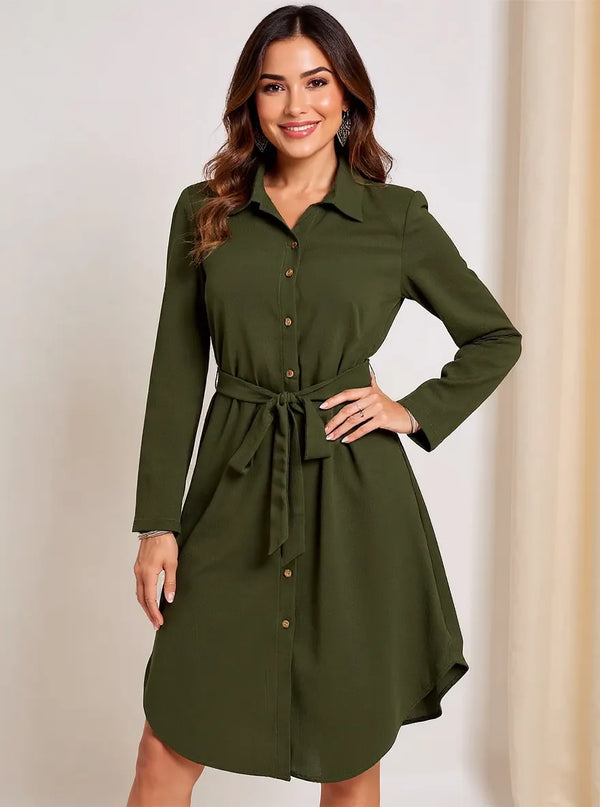 Woman wearing a green casual button down dress with a belt against a plain background