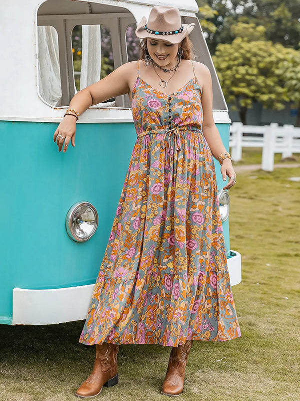 Woman in a floral maxi dress and cowboy boots standing next to a turquoise and white van.