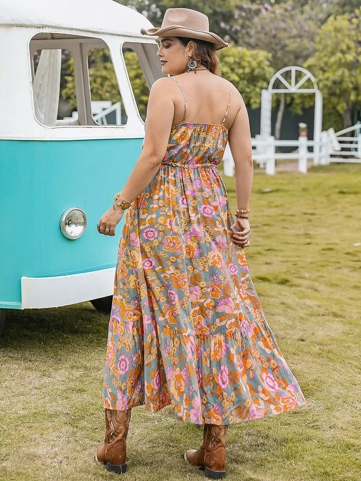 Woman in a floral maxi dress standing in front of a vintage van on grass