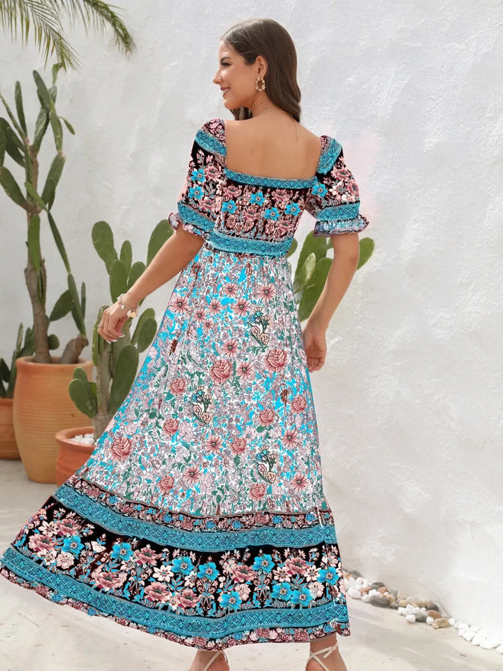 Woman wearing a floral midi dress with a white background and plants.