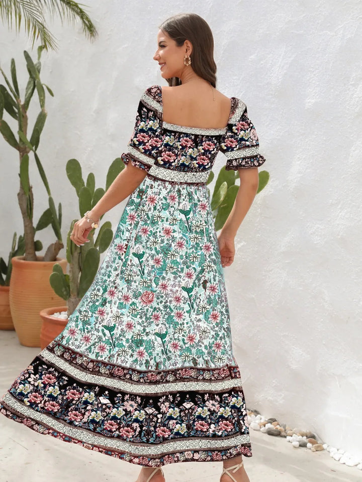 Woman wearing a floral midi dress with a white background and plants.