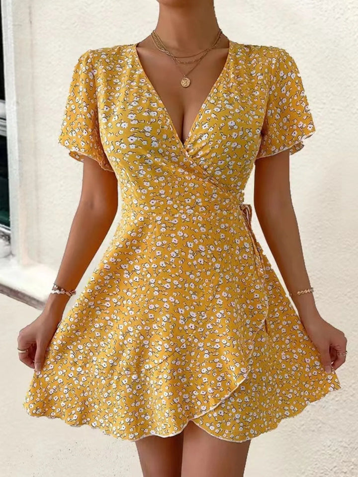 Yellow floral dress worn by a person on a neutral background