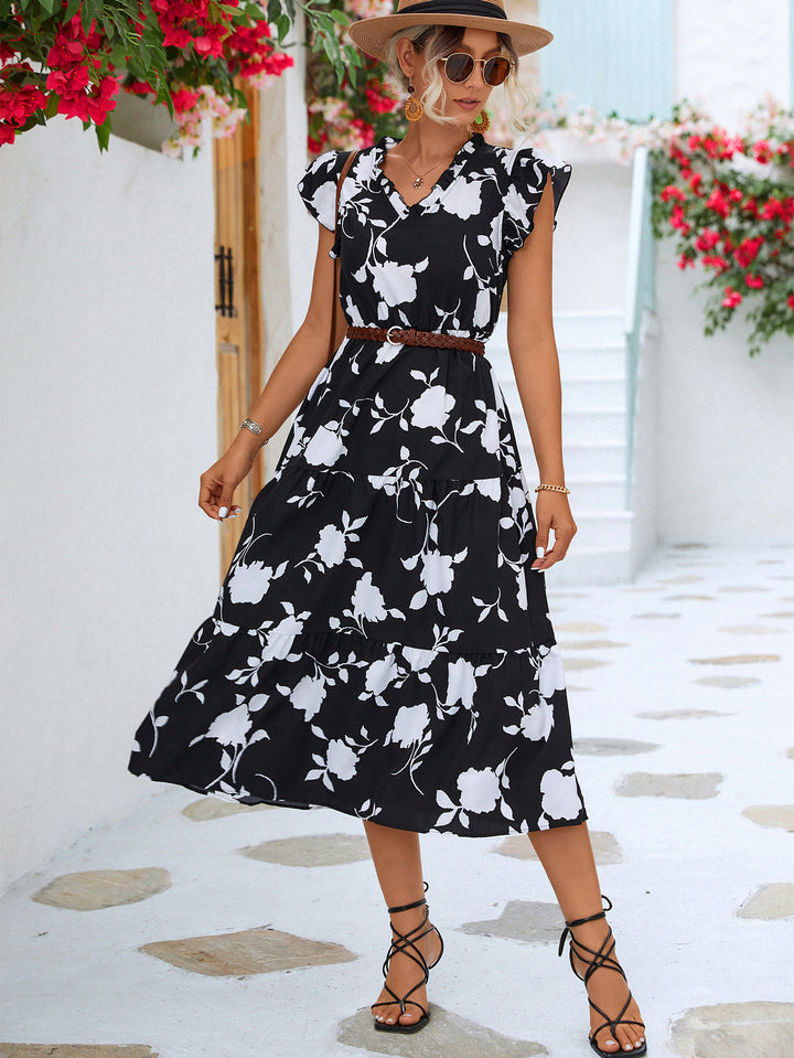Woman wearing a black floral dress with a white background