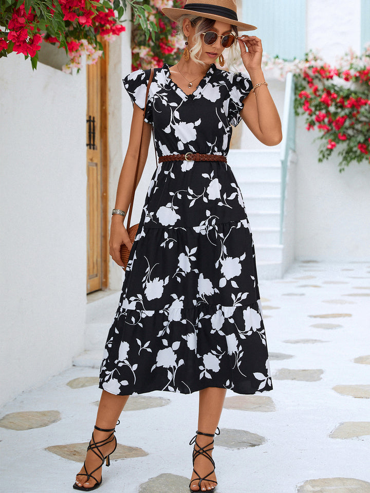 Woman wearing a black floral dress with a white background