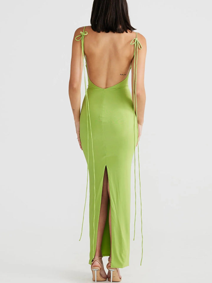 Green maxi dress with open back and side slits on a white background