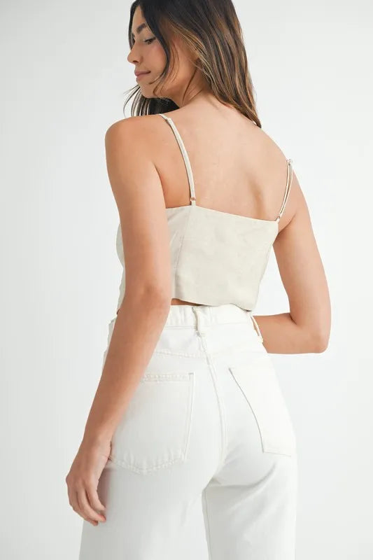 Woman wearing a white top and pants on a plain background