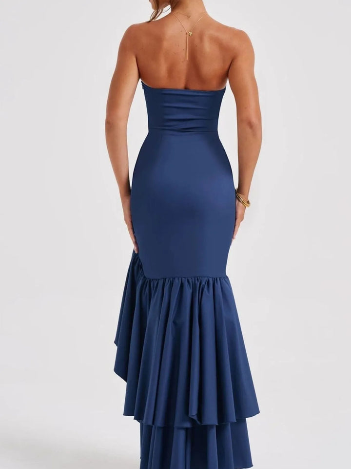 Navy blue strapless gown with a layered skirt on a white background