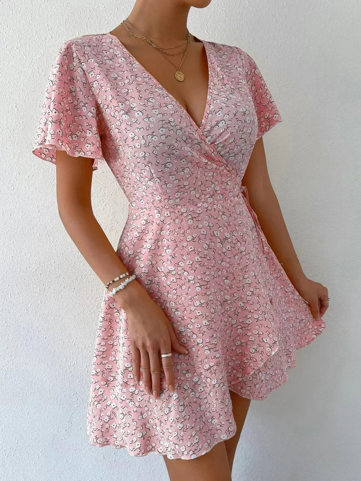 Pink floral dress worn by a person on a white background