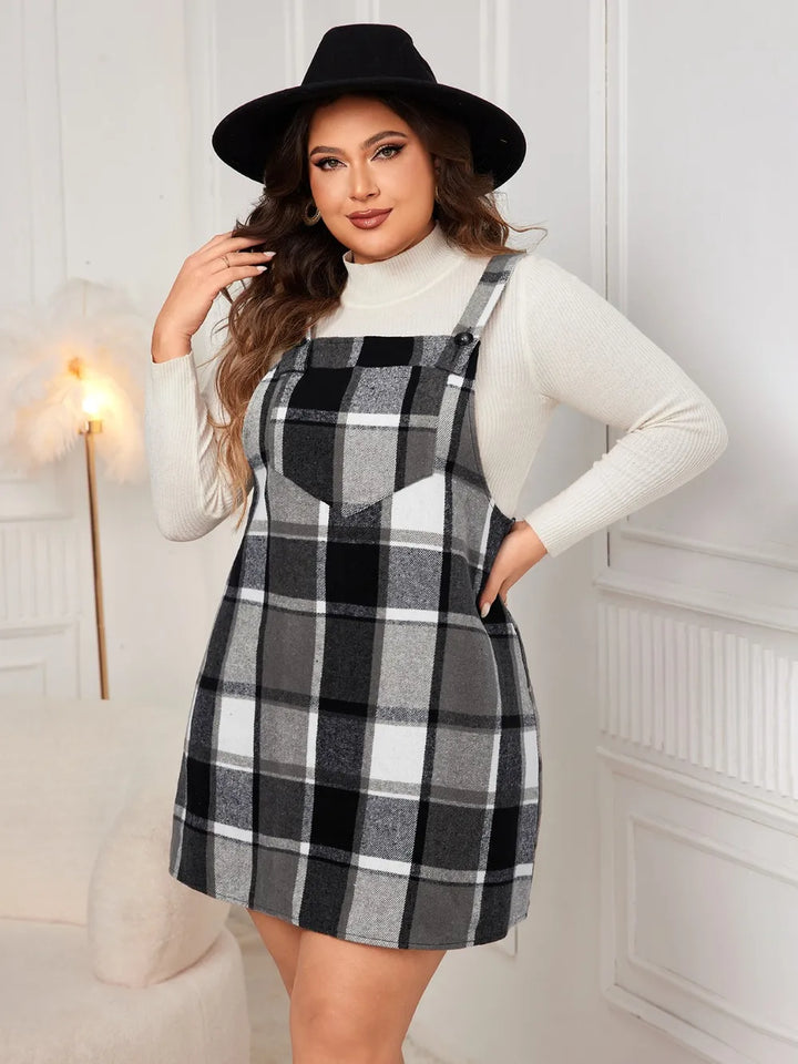 Woman wearing a black and white checkered dress with a white turtleneck and black hat indoors.