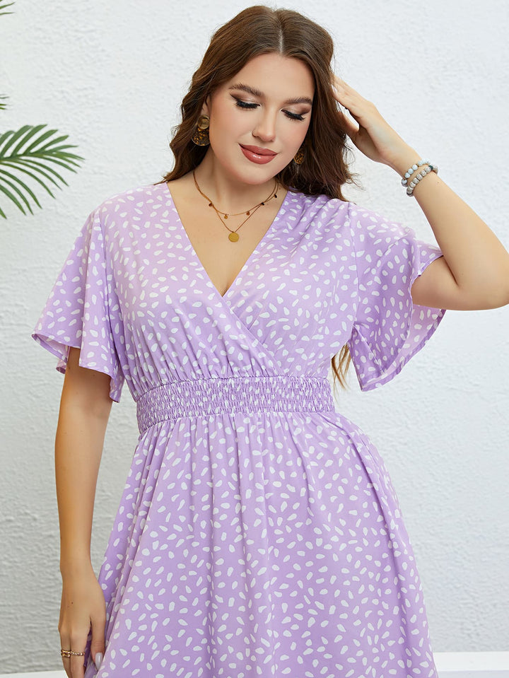 Woman wearing a lavender printed midi dress against a light background