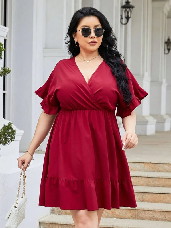 Woman wearing a red dress standing on steps outside a building