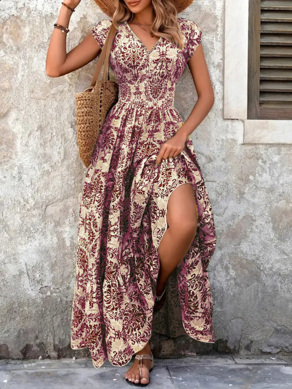 Woman wearing a purple maxi floral dress with a stone wall background
