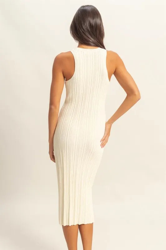 Woman wearing a white ribbed midi dress against a plain background
