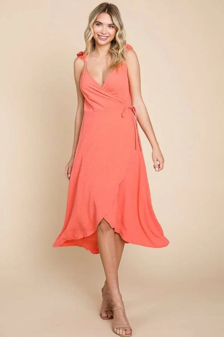 Woman wearing a coral dress against a beige background