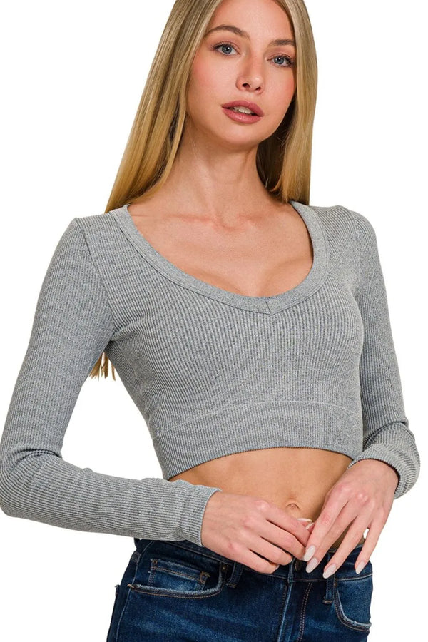 Woman wearing a gray long-sleeve crop top against a white background