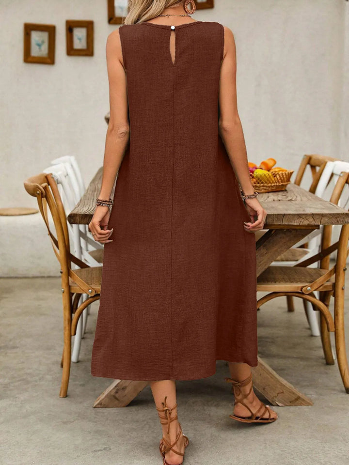 Woman wearing a dark brown midi dress in a dining room setting