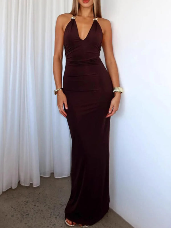 Woman wearing a wine red halter neck dress against a white curtain background