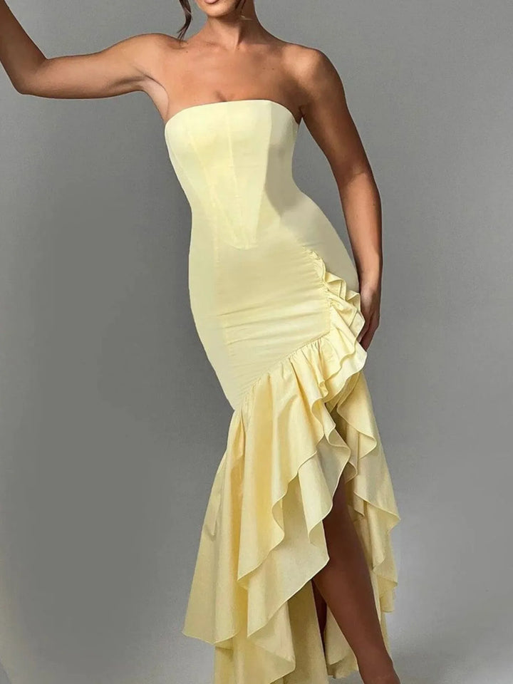 Yellow strapless dress with ruffled skirt on a gray background