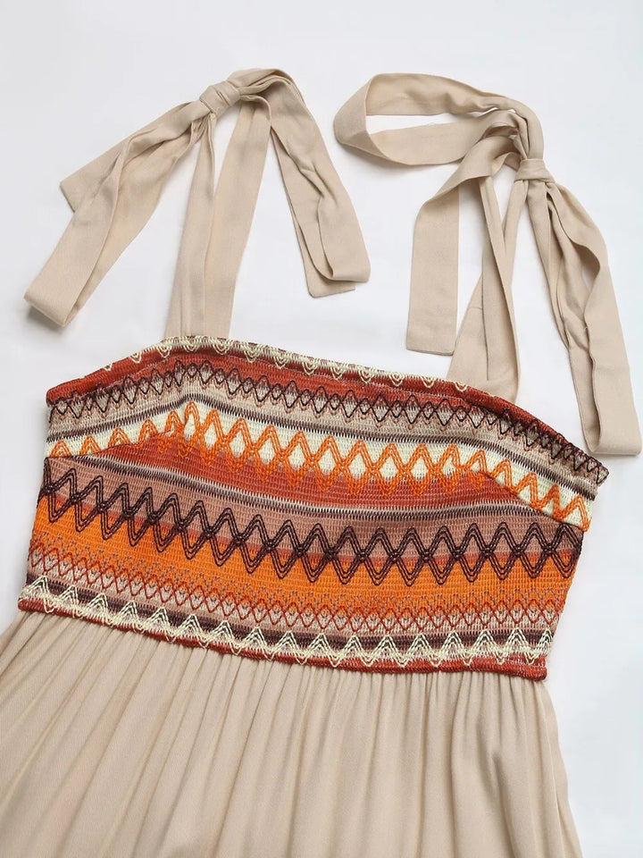 Beige halter top with patterned design and tied straps on a white background