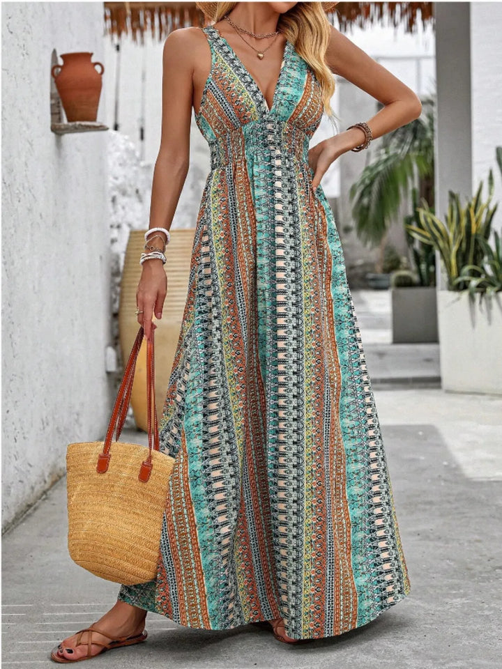 Woman wearing a colorful patterned maxi dress holding a yellow bag outdoors.
