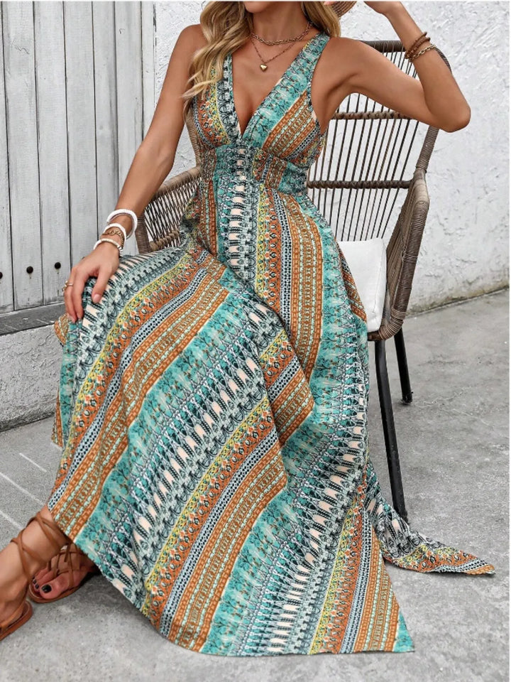 Woman wearing a patterned maxi dress sitting on a chair outdoors.