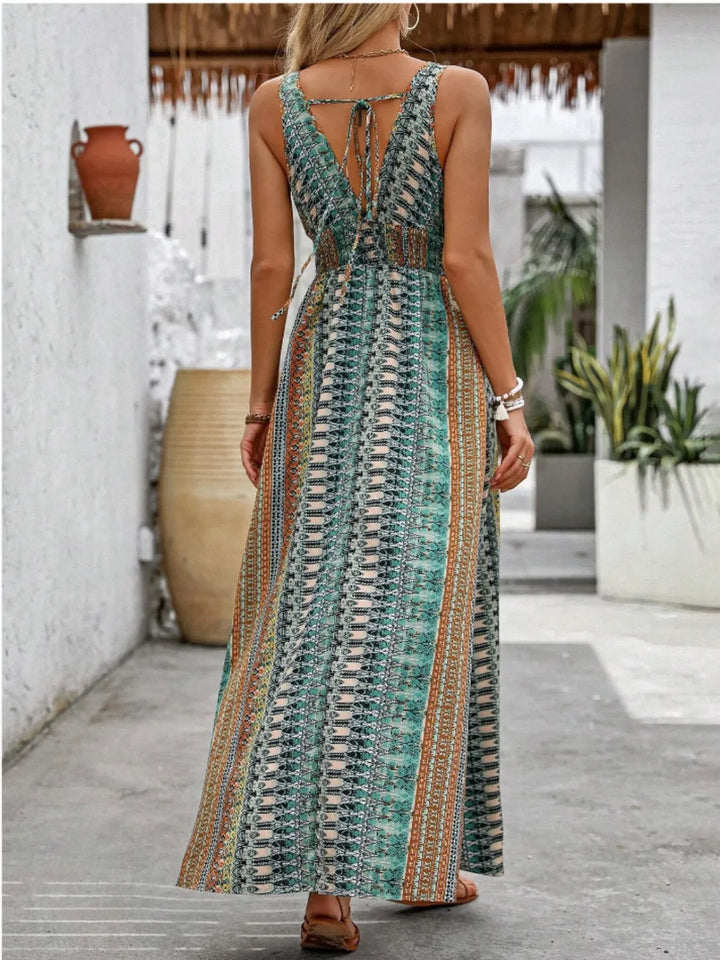 Woman wearing a patterned maxi dress with an open back, standing on a patio.