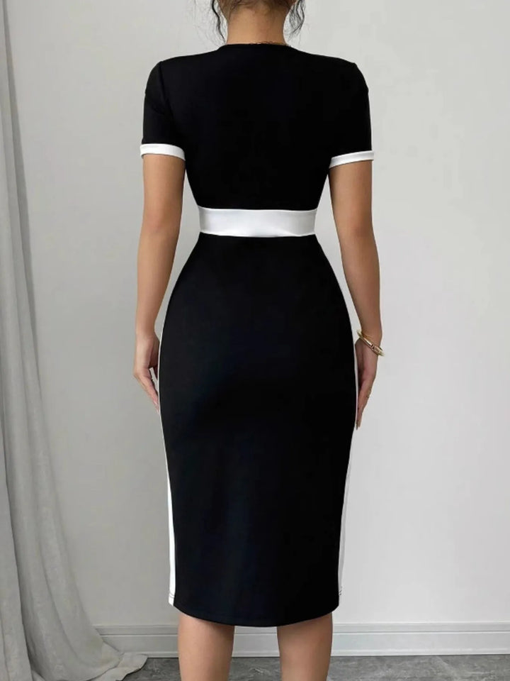 Black midi dress with white trim worn by a person against a plain background