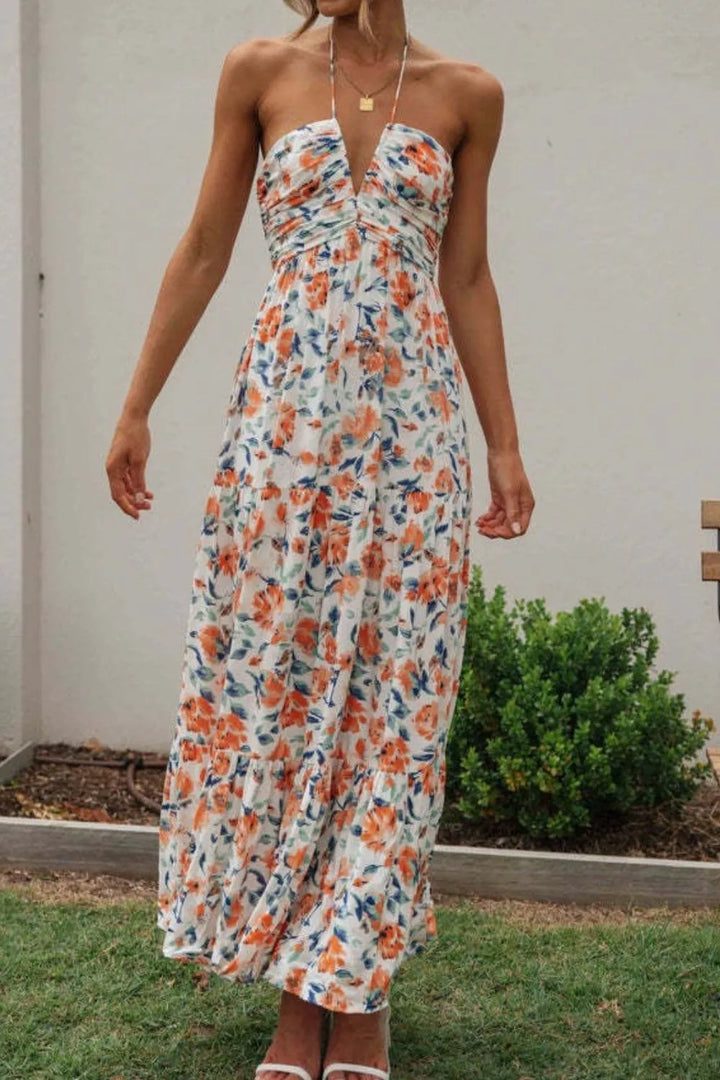 Woman wearing a floral maxi dress standing outdoors with a neutral background