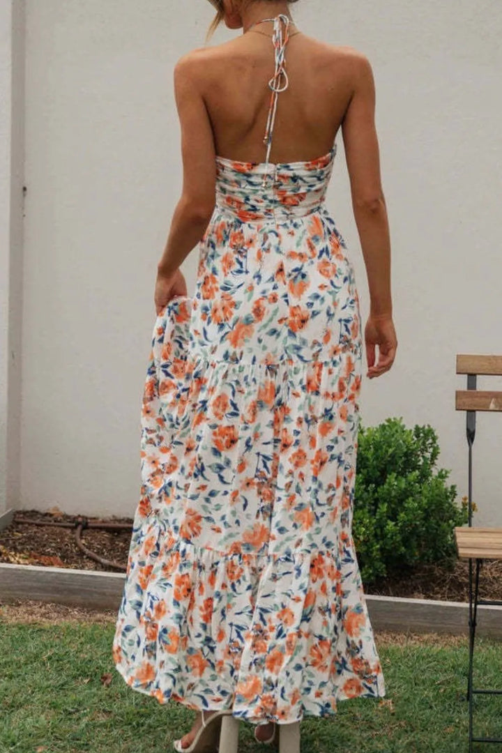 Woman wearing a watermelon pink floral maxi dress with a white background
